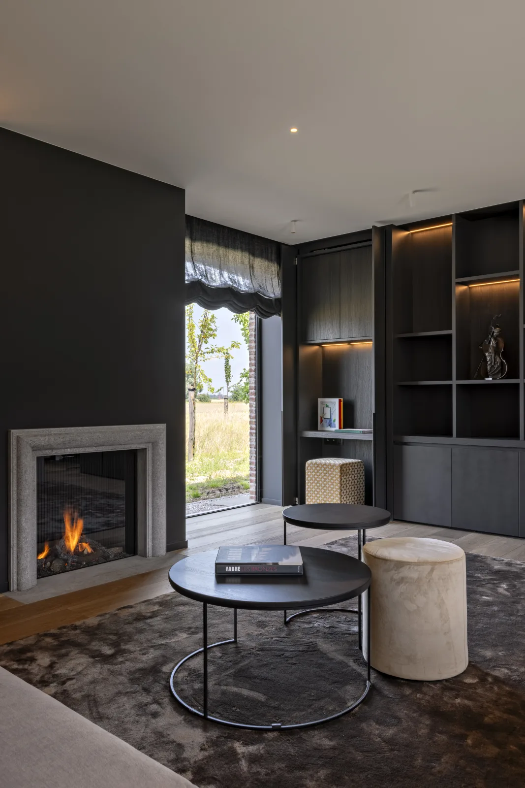 Zithoek met haard in een donker afgewerkte woonkamer