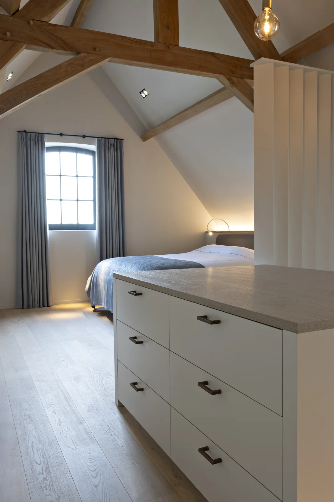 Slaapkamer met eikenhouten vloer en linnen gordijn